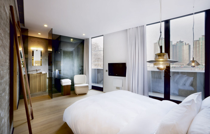 Au bout de la chambre, une salle de bains entièrement vitrée.