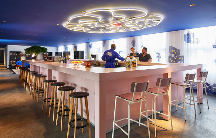 L’imposant bar central, qui fait aussi office d’accueil, propose des boissons à volonté, toute la journée.