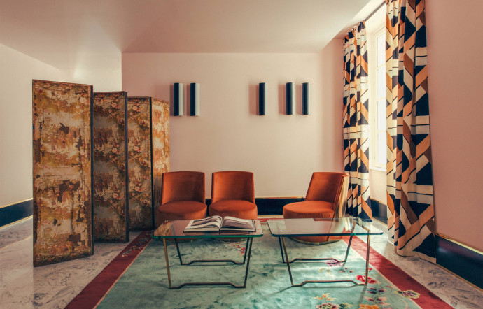 L’hôtel Saint-Marc, à Paris, est installé dans un bâtiment de la fin du XVIIIe siècle. Dimore Studio a choisi d’apporter des touches rétro, comme ici un paravent patiné par le temps et un tapis vintage.