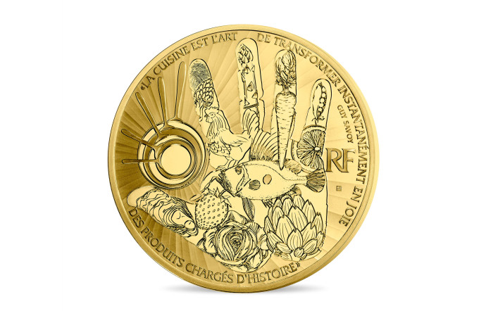 Monnaie en forme d’oeuf au plat. Au revers, figure l’empreinte de la main de Guy Savoy et, comme un tatouage, celle du graveur de la monnaie de paris.
