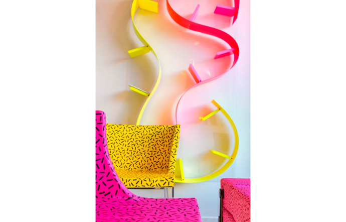 Hommage de l’installation Kartell Goes Sottsass – a tribute to Memphis, avec des pièces au motif Bacterio et un clin d’oeil au fauteuil Bel Air de Peter Shire.