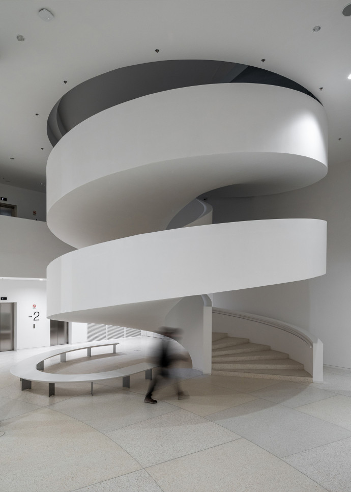 Un escalier monumental relie les différents niveaux du musée tandis que 30 000 feuilles d’arbres décoratives, hymne à la nature environnante, courent sur le plafond.