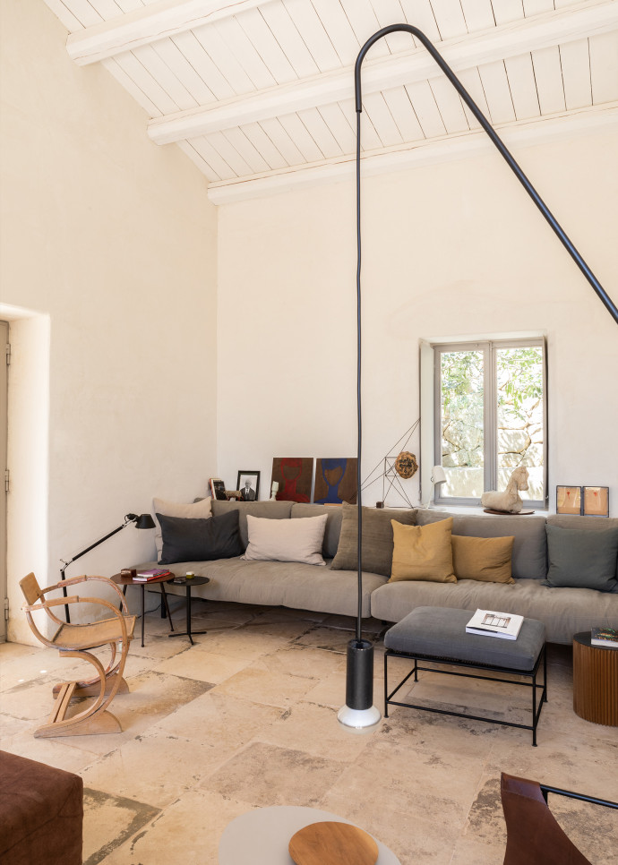 Canapé sur mesure, prototype de pouf Girgenti (Baxter) et lampadaire Inchino (Serax), conçus par le propriétairedes lieux, et chaise en bois vintage.