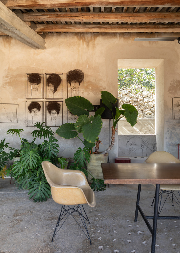 Sous les poutres en bois trône une grande table conviviale, entourée de murs écaillés.