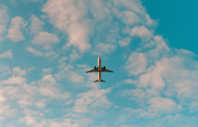 prendre le train plutot que l'avion voyager plus écologiquement un avion qui vole dans le ciel